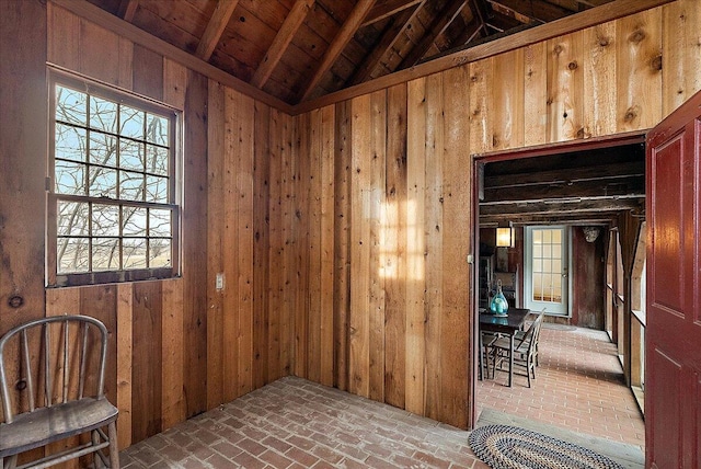 interior space featuring lofted ceiling and wooden walls