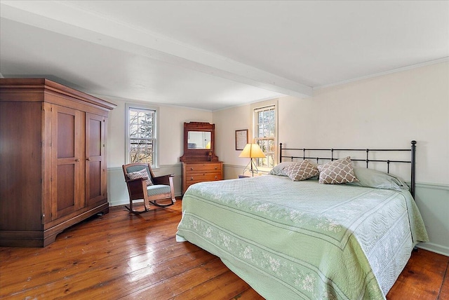 bedroom with beam ceiling and dark hardwood / wood-style floors