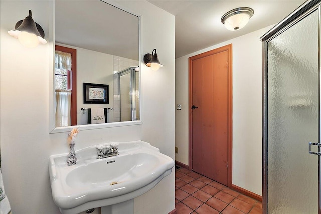 bathroom with tile patterned flooring, a shower with door, and sink