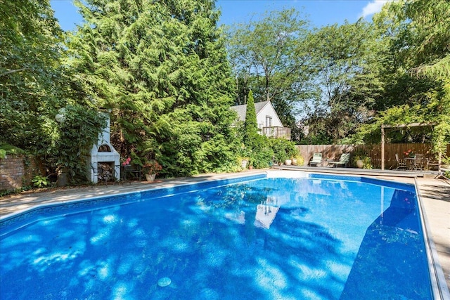 view of swimming pool with an outdoor fireplace