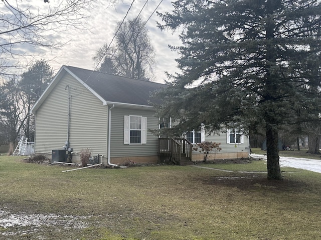 view of home's exterior with a yard and central AC