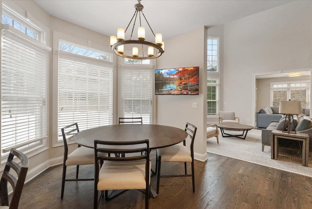 dining area featuring dark hardwood / wood-style flooring, a notable chandelier, and a high ceiling