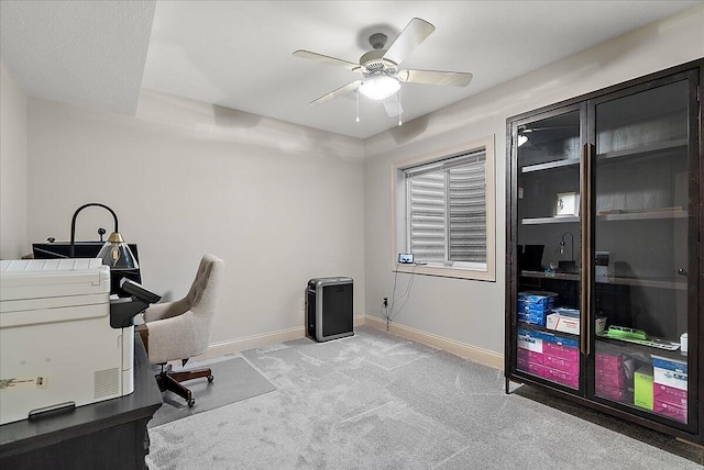 carpeted office space with ceiling fan