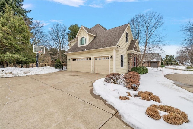 snow covered property with a garage