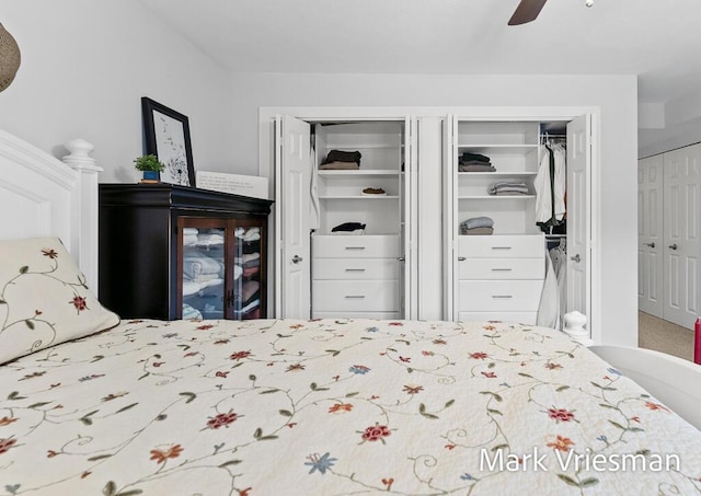 bedroom with ceiling fan and two closets