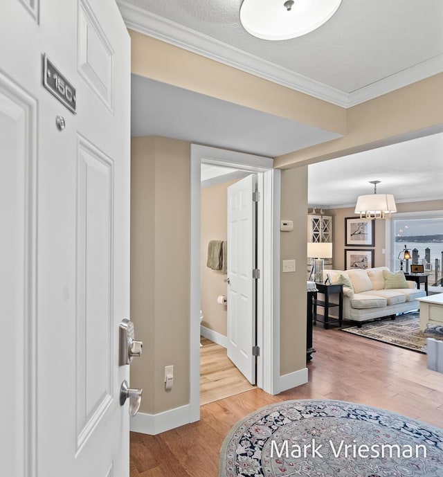 hall with ornamental molding and hardwood / wood-style floors