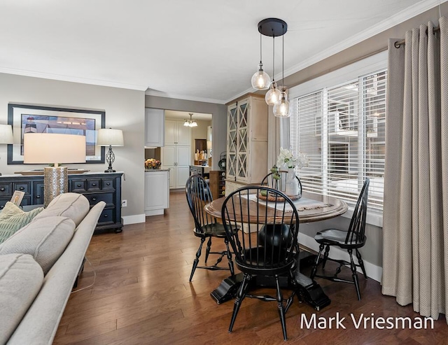 dining area with dark wood-type flooring and ornamental molding