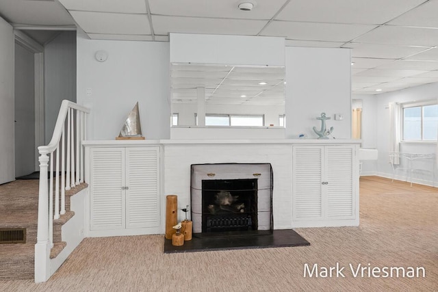 living room with carpet and a paneled ceiling