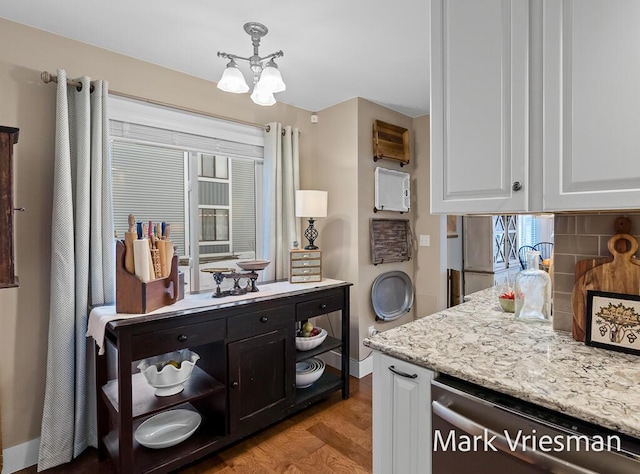 kitchen featuring white cabinetry, dishwasher, decorative backsplash, light stone countertops, and light wood-type flooring