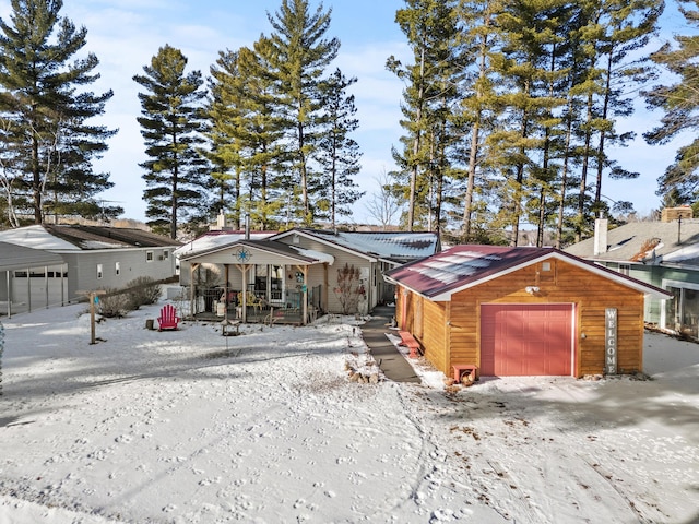 view of front of house featuring a garage, an outdoor structure, and covered porch