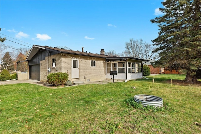 back of house featuring a yard, a sunroom, and a garage