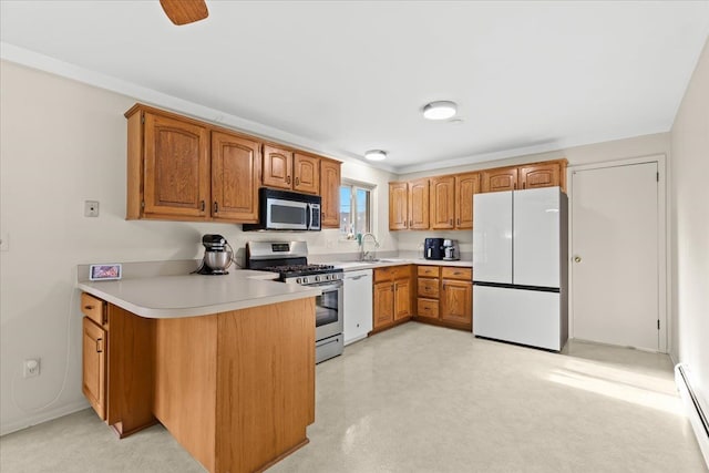 kitchen featuring baseboard heating, appliances with stainless steel finishes, kitchen peninsula, and sink