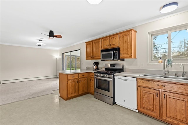 kitchen featuring sink, ornamental molding, a baseboard heating unit, kitchen peninsula, and stainless steel appliances