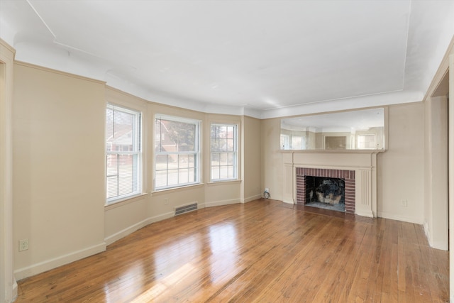 unfurnished living room with a wealth of natural light, a fireplace, and light hardwood / wood-style flooring