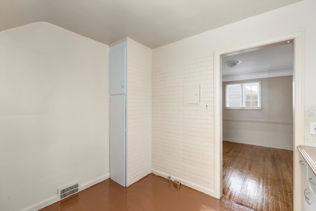 unfurnished room with brick wall