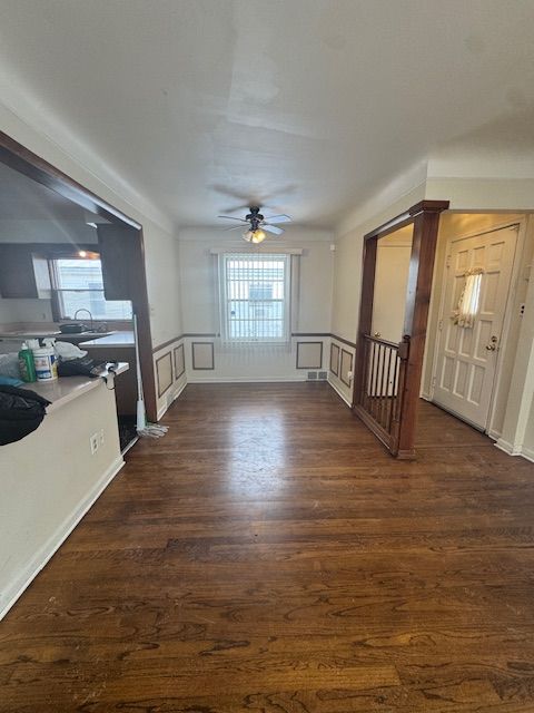 unfurnished living room featuring dark hardwood / wood-style floors and ceiling fan