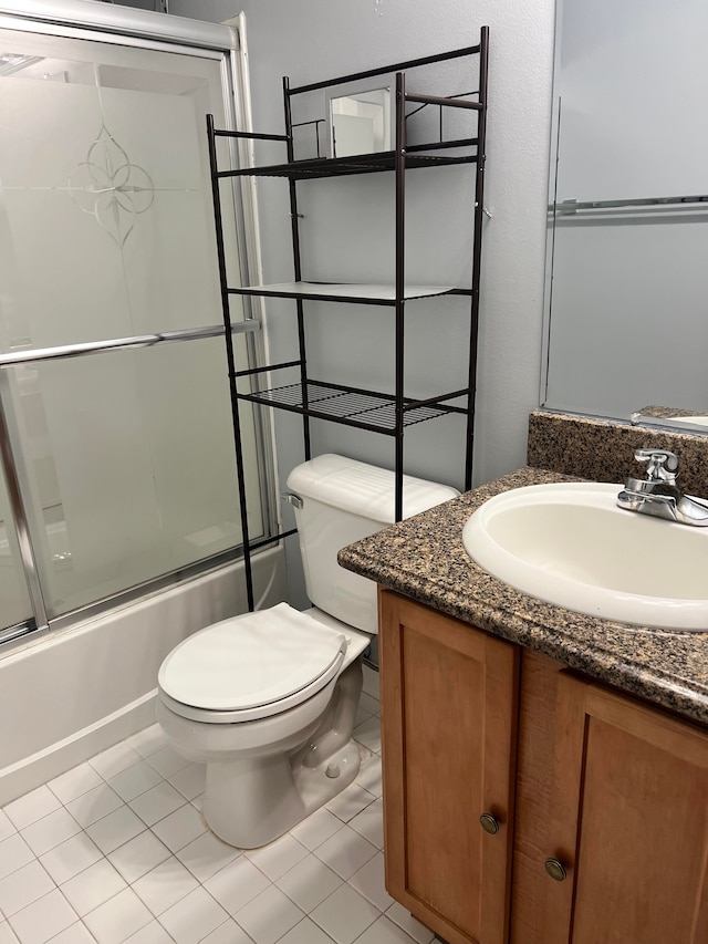 full bathroom with enclosed tub / shower combo, vanity, toilet, and tile patterned floors