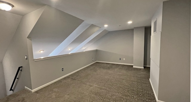 additional living space featuring lofted ceiling and dark carpet