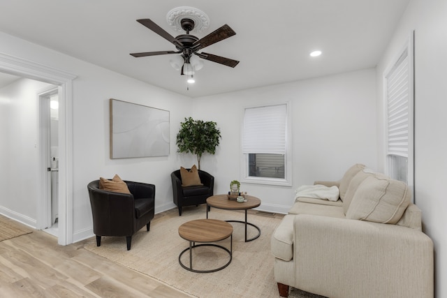 living room featuring light hardwood / wood-style floors and ceiling fan