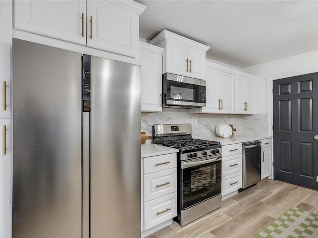 kitchen with white cabinetry, decorative backsplash, light hardwood / wood-style flooring, and appliances with stainless steel finishes