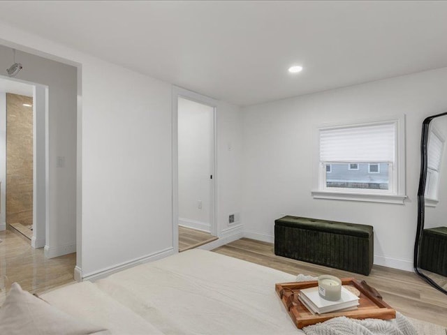 bedroom featuring radiator heating unit and light hardwood / wood-style floors