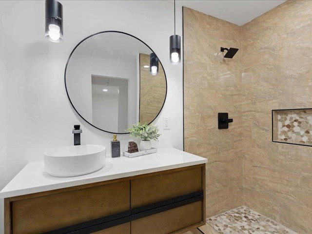 bathroom featuring tiled shower and vanity