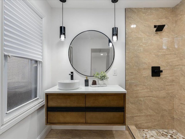 bathroom with vanity and a tile shower