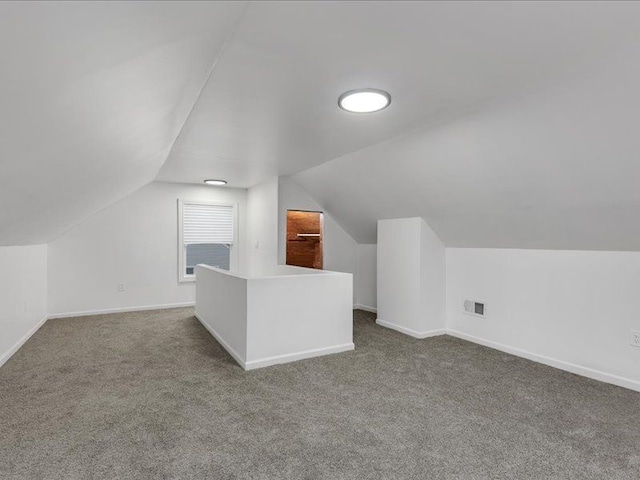 bonus room featuring vaulted ceiling and carpet flooring