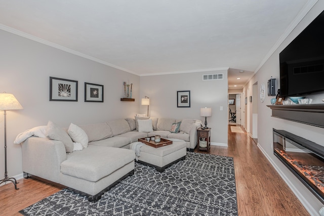 living room with hardwood / wood-style flooring and crown molding