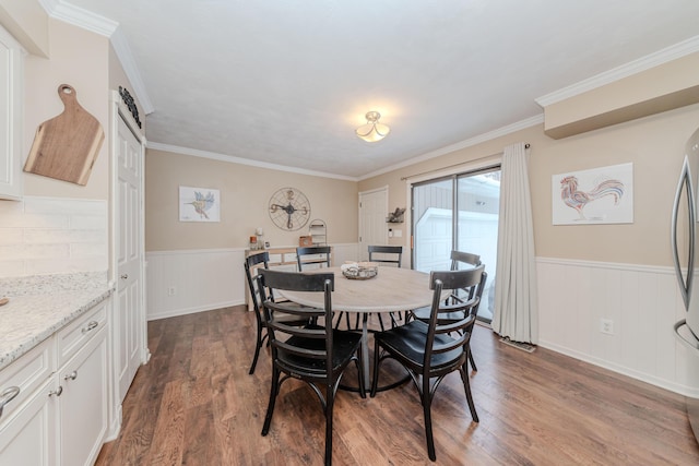 dining space with dark wood-type flooring and ornamental molding