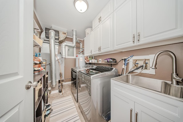 clothes washing area featuring sink, cabinets, gas water heater, light tile patterned flooring, and separate washer and dryer