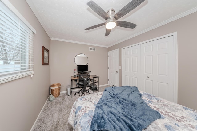 bedroom with crown molding, a textured ceiling, a closet, ceiling fan, and carpet