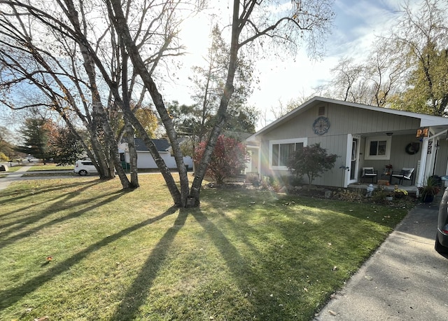 view of side of property with a lawn and covered porch