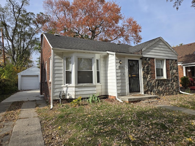 bungalow featuring a garage, an outdoor structure, and a front lawn