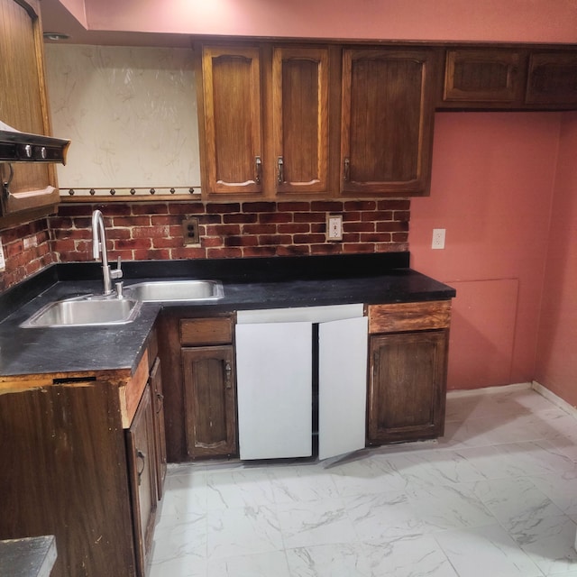 kitchen featuring dishwashing machine and sink