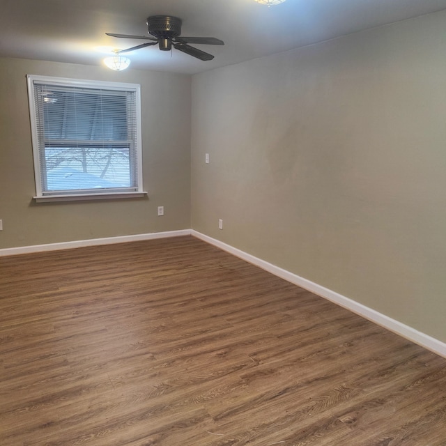 spare room featuring dark wood-type flooring and ceiling fan