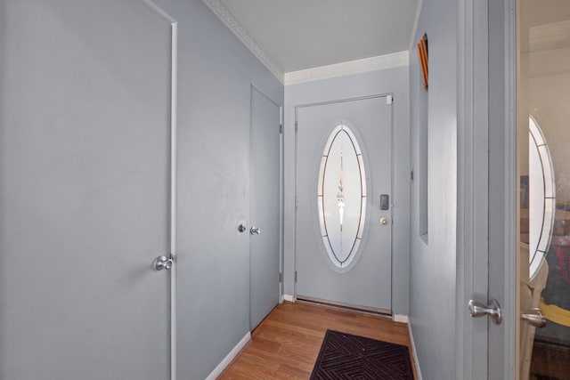 entryway featuring light wood-type flooring, baseboards, and crown molding