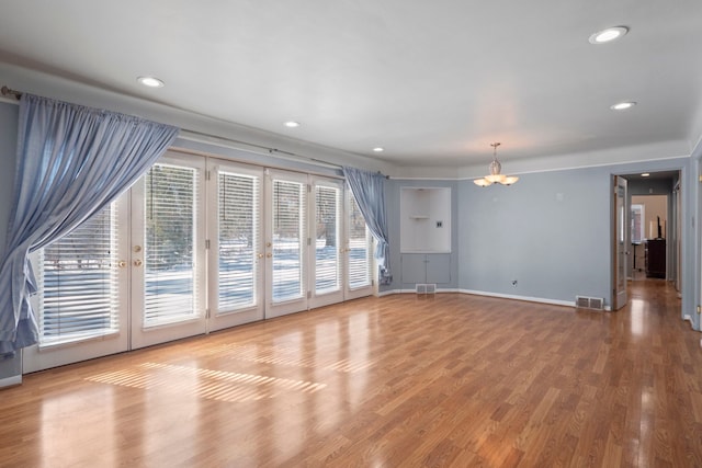 unfurnished living room with recessed lighting, wood finished floors, visible vents, and baseboards