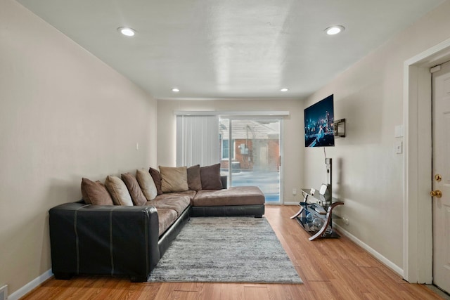 living area featuring light wood-style floors, baseboards, and recessed lighting