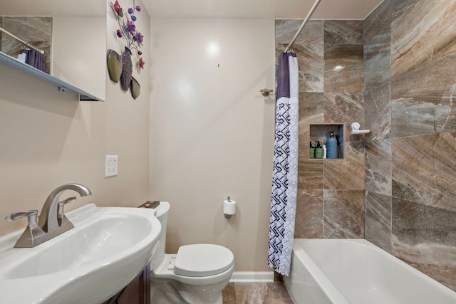 full bathroom featuring shower / tub combo with curtain, baseboards, a sink, and toilet