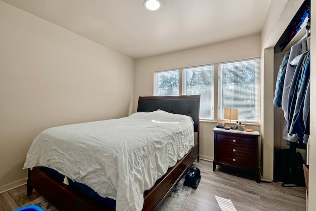 bedroom featuring light wood-style flooring and baseboards