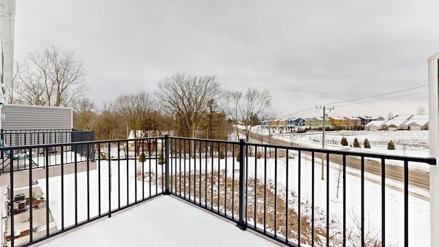 view of snow covered back of property