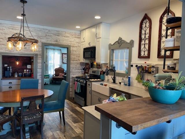 kitchen with hanging light fixtures, gas range, kitchen peninsula, and a kitchen bar