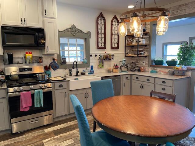 kitchen featuring stainless steel appliances, sink, pendant lighting, and backsplash