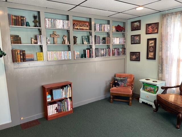 living area with dark carpet and built in shelves