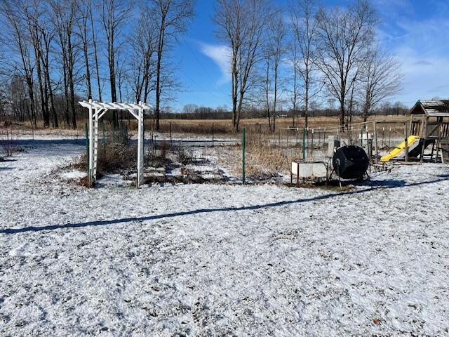 yard layered in snow with a playground