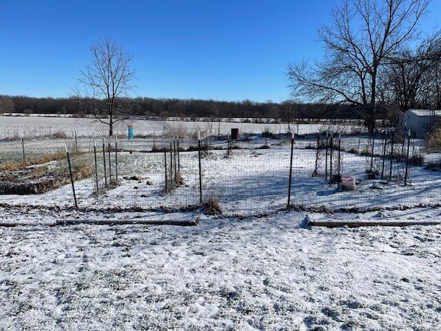 yard layered in snow featuring a rural view