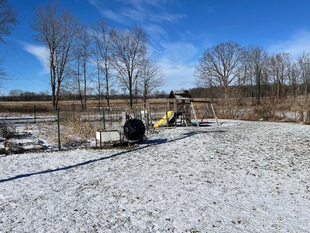 yard covered in snow with a playground