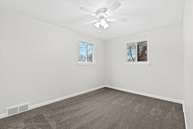 unfurnished room with dark carpet and ceiling fan