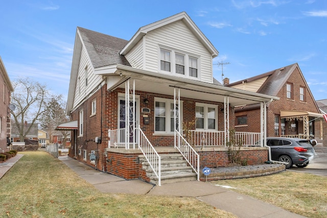 view of front of home featuring covered porch and a front lawn